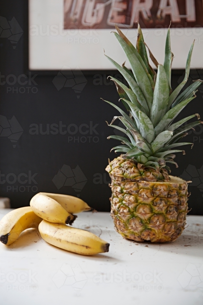Still life table top in kitchen of bananas and pineapple - Australian Stock Image