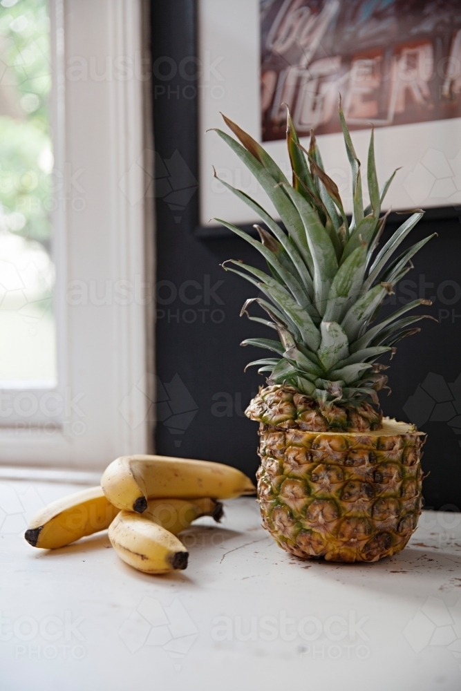 Still life table top in kitchen with bananas and pineapple - Australian Stock Image