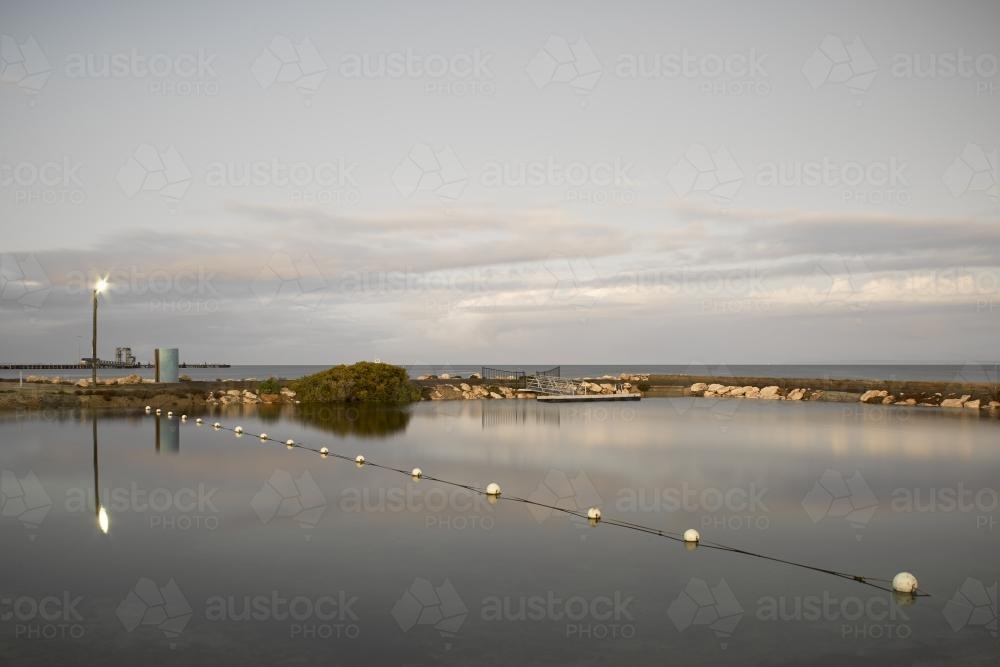Still ocean pool in grey light at dusk - Australian Stock Image