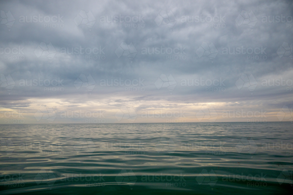 Still water beneath a brooding sky at dusk - Australian Stock Image