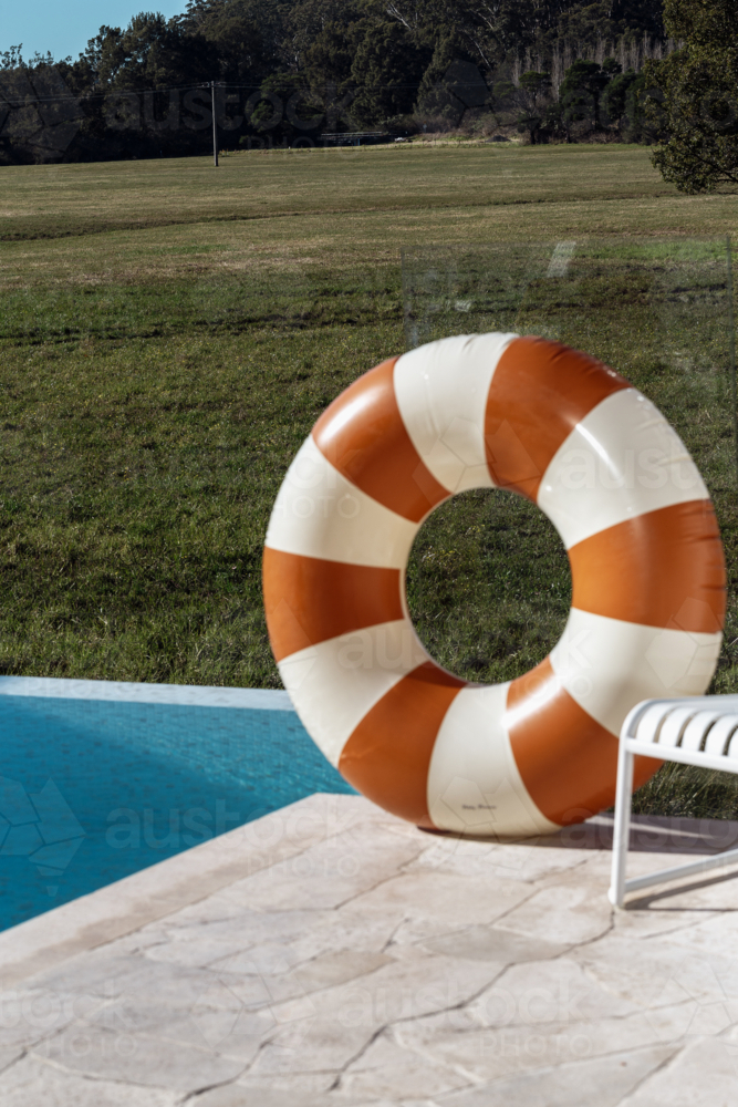 Stiped Inflatable Poolring by Infinity Pool with Paddock Background - Australian Stock Image