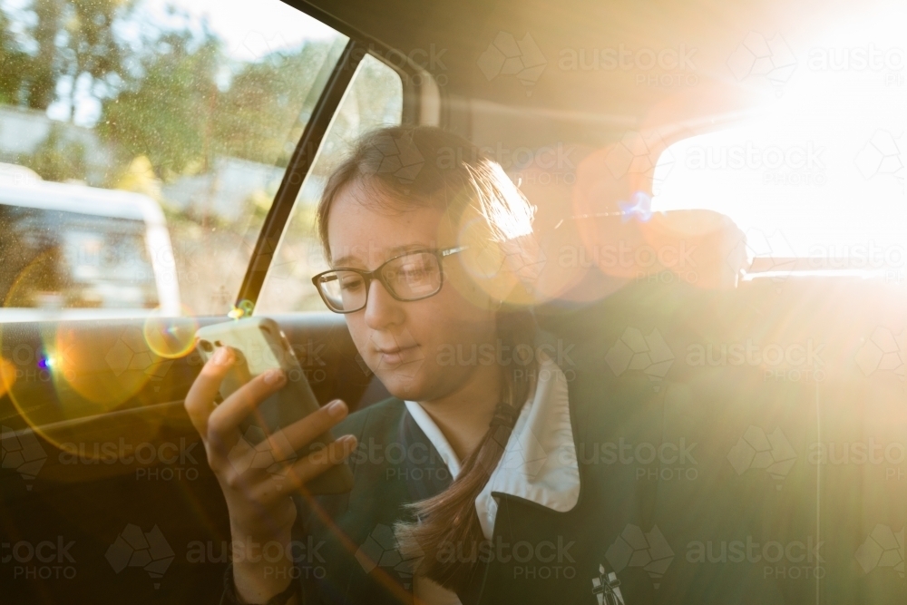 teen in school uniform, being driven to school in the morning - Australian Stock Image