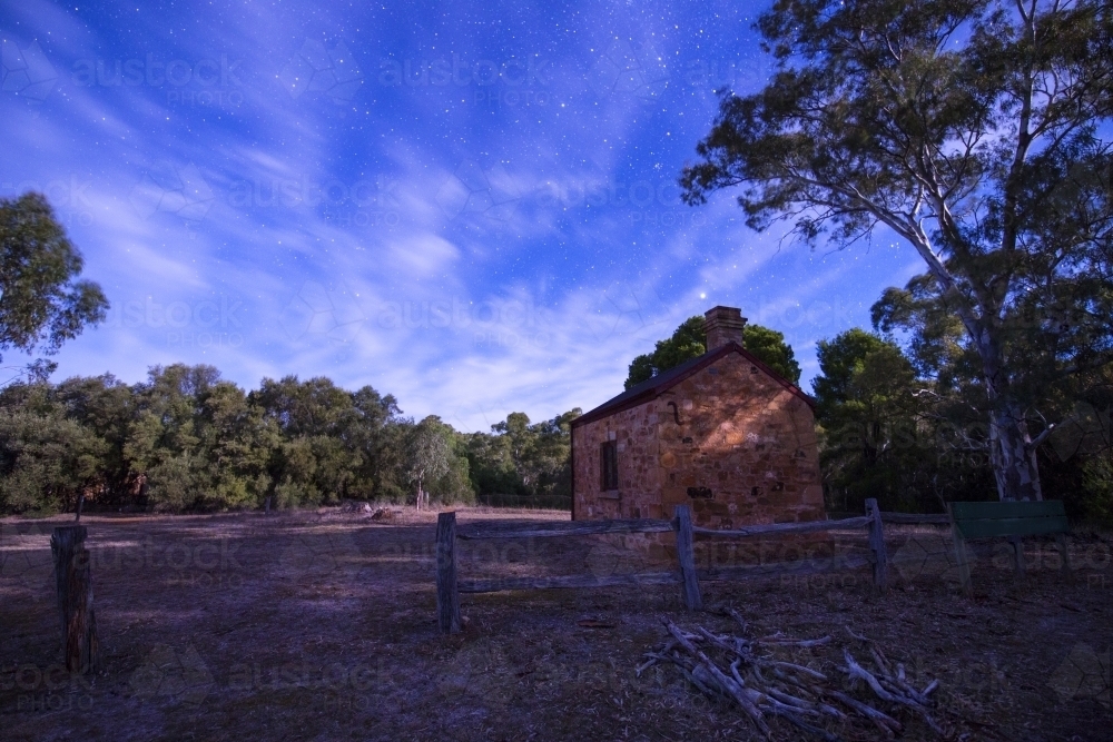 Stone hut and trees at night - Australian Stock Image