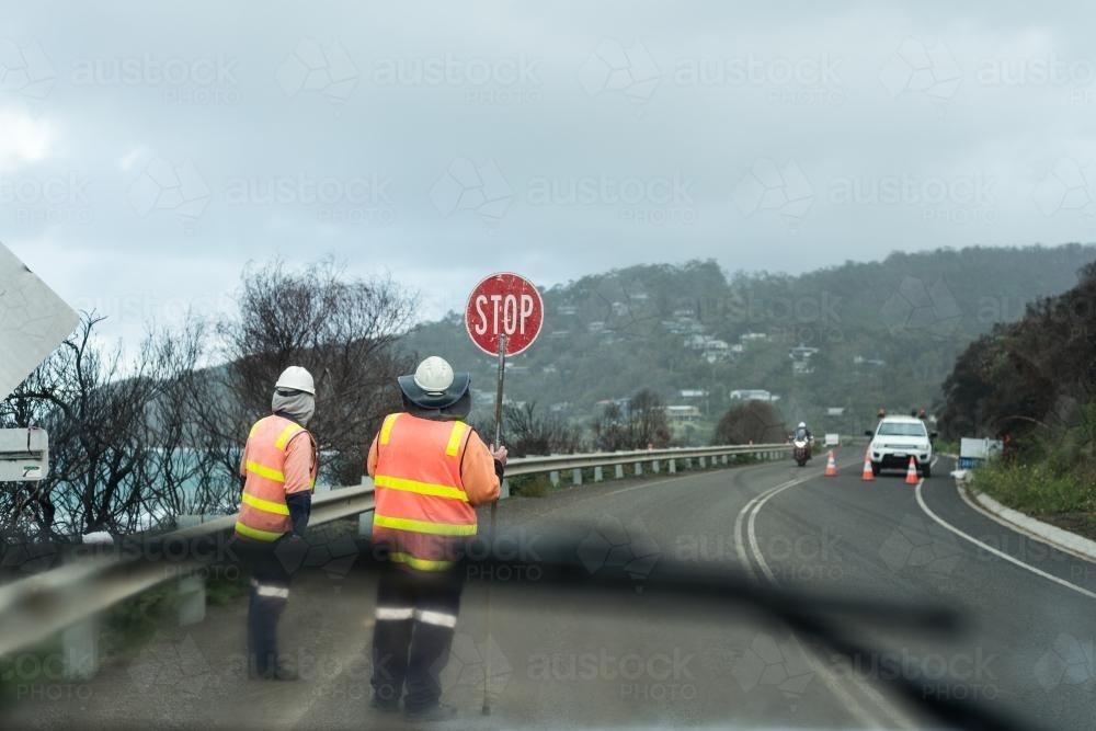 stop go workers on a stretch of highway, working on a cold, gloomy day. - Australian Stock Image