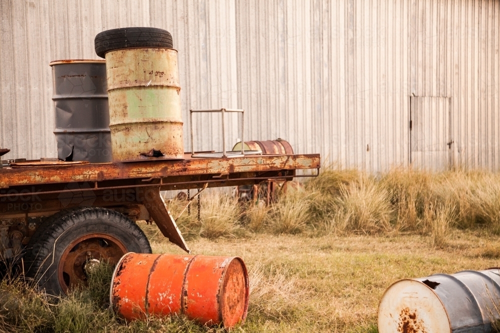 Storage drums lying near shed on farm - Australian Stock Image