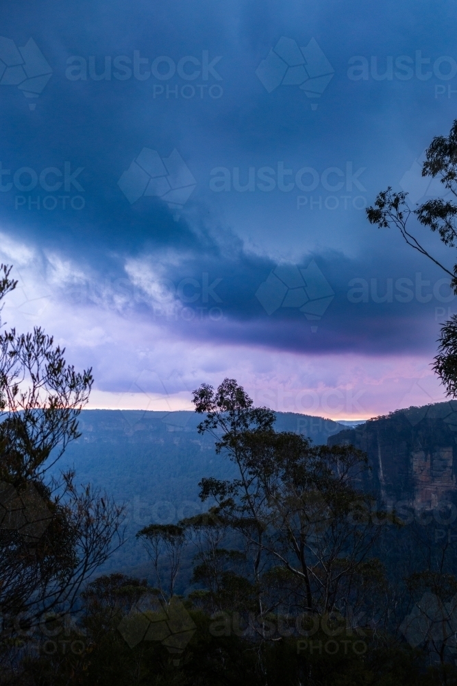 storm clouds above Blue Mountain scenery with gum tree in foreground - Australian Stock Image