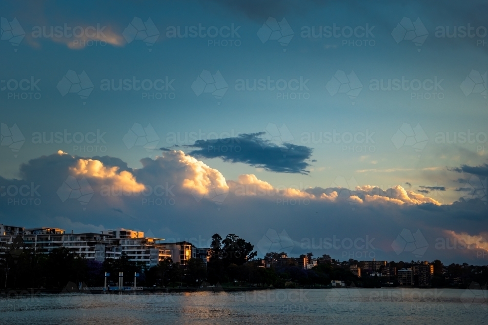 Storm clouds above riverside suburb - Australian Stock Image