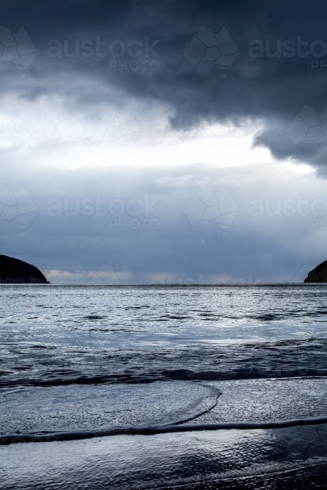 Storm clouds darken the sky over a beach - Australian Stock Image