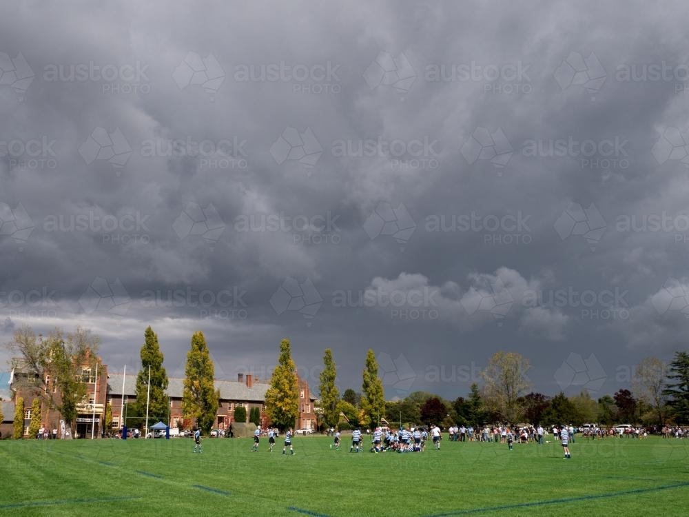 Storm clouds over a football match at The Armidale School - Australian Stock Image