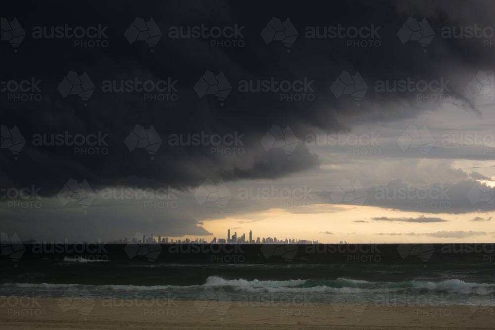 Storm clouds over sea with Gold Coast building in the distance - Australian Stock Image