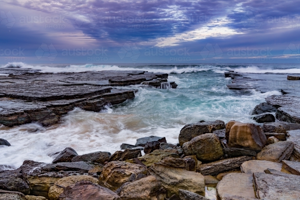 Stormy waves at a rocky beach inlet - Australian Stock Image