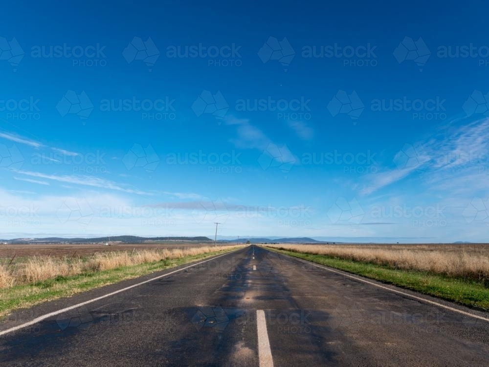 Straight tarred road disappearing into the distance - Australian Stock Image