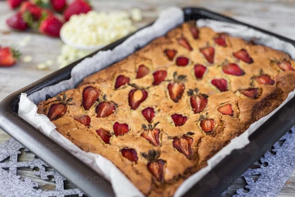 strawberry white chocolate blondie straight out of the oven, in a baking pan - Australian Stock Image