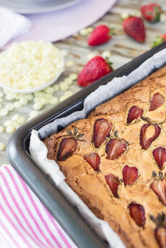 strawberry white chocolate blondie straight out of the oven, in a baking pan - Australian Stock Image