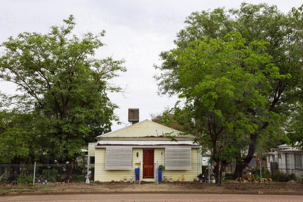 Street view of an old yellow weatherboard house in an outback town - Australian Stock Image