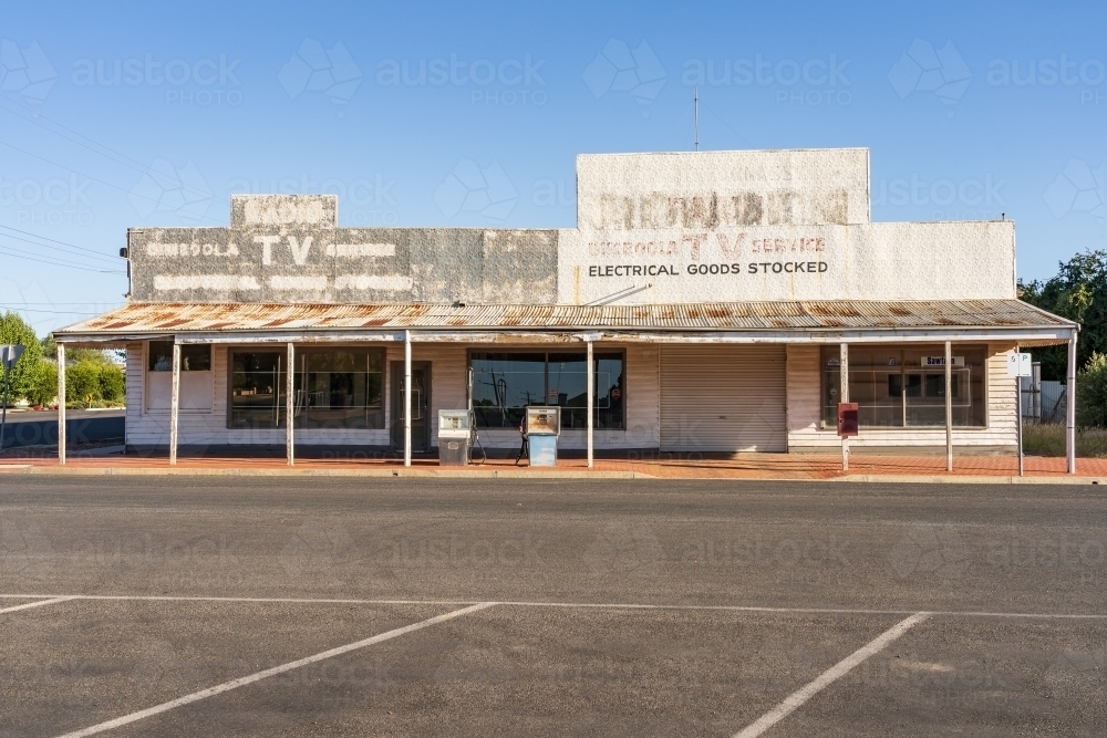 Streetscape of old deserted shopfronts with faded signs on their facades - Australian Stock Image