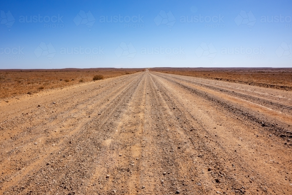 stretch of dirt road in desert landscape - Australian Stock Image
