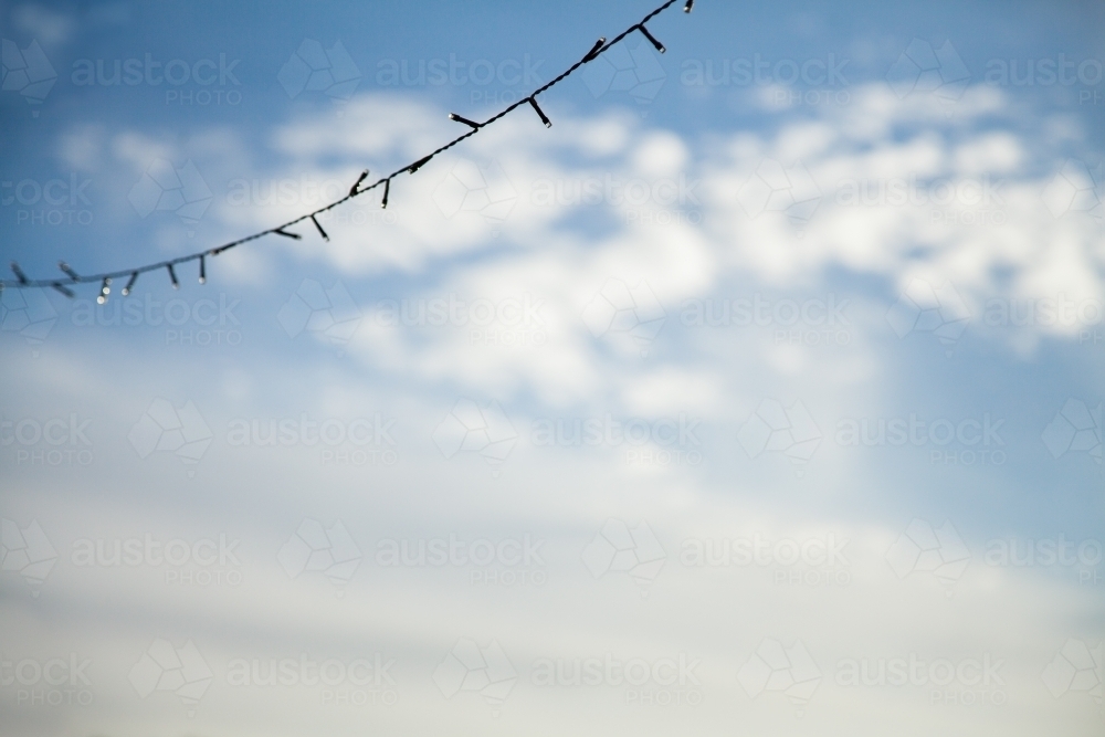 String of fairy lights against cloudy blue sky - Australian Stock Image