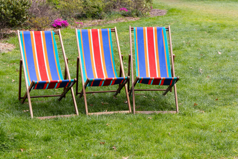Striped brightly coloured outdoor deck chairs - Australian Stock Image