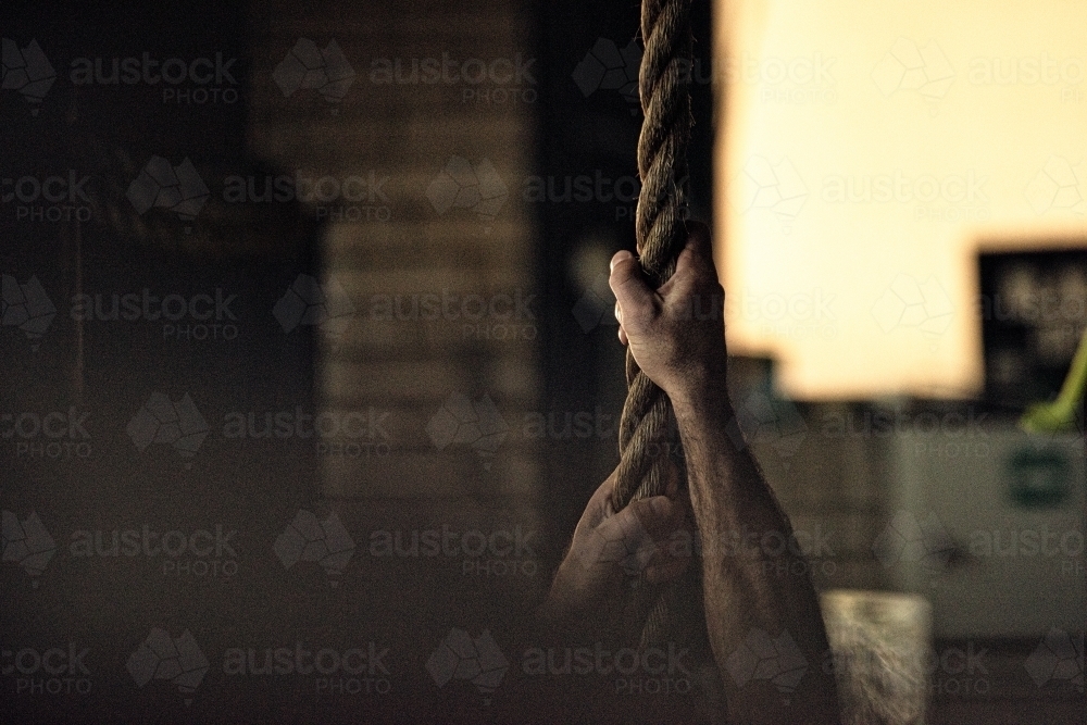 Strong hands and arms hold rope, strength training - Australian Stock Image
