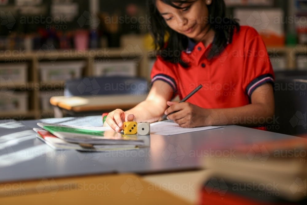 Student using dice to solve maths problems - Australian Stock Image
