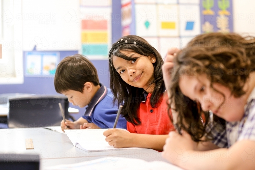 Students concentrating writing in the classroom - Australian Stock Image