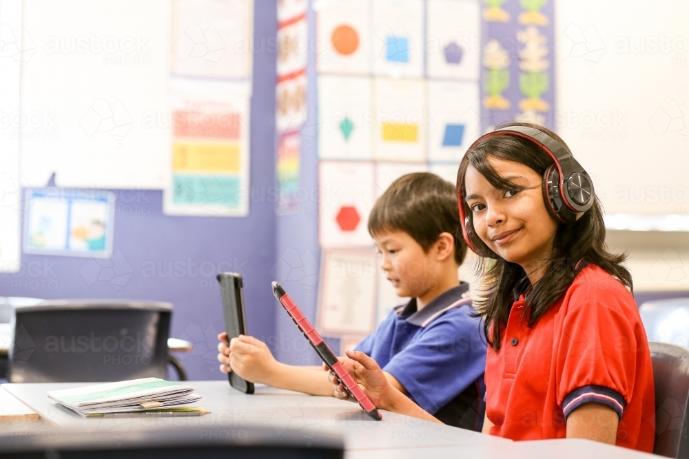 students in the classroom with headphones and iPads - Australian Stock Image