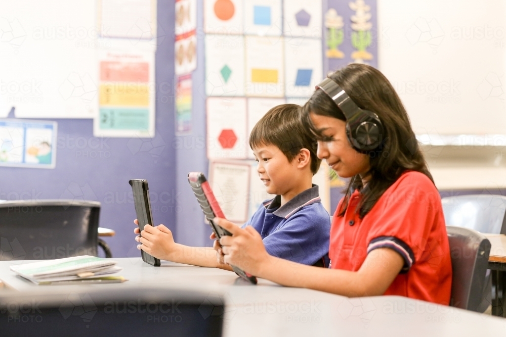students in the classroom with headphones and iPads - Australian Stock Image