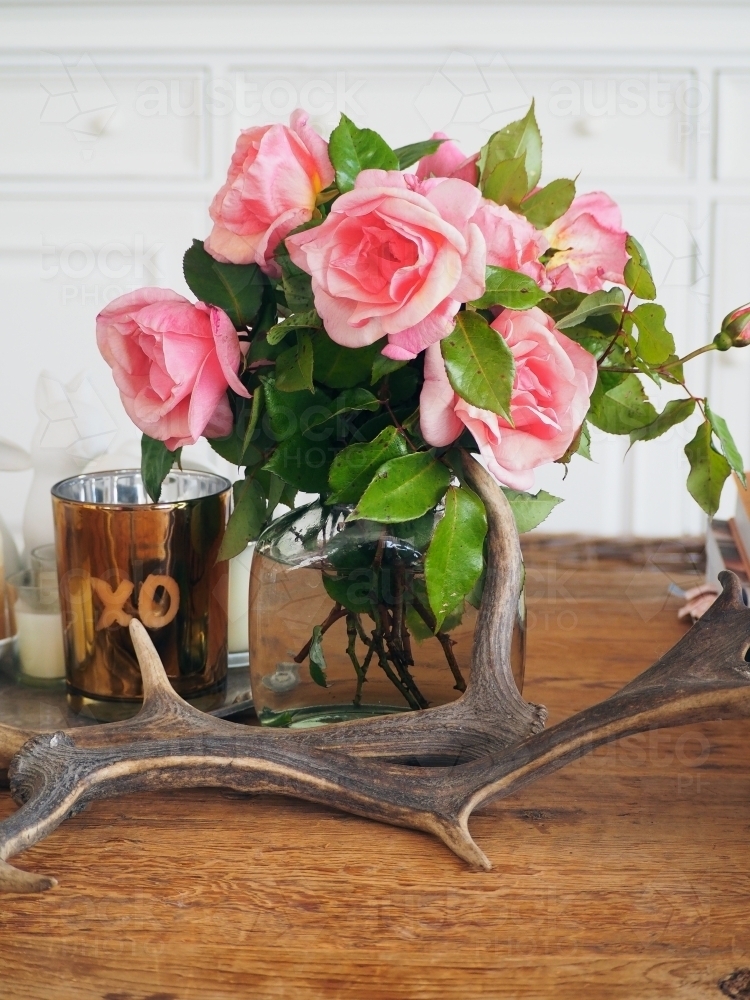 Styled coffee table with flowers, candle and antlers - Australian Stock Image