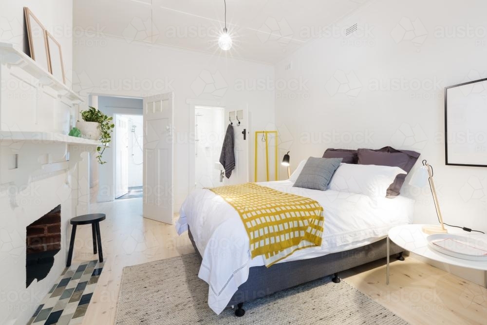 Stylish contemporary bedroom with ensuite and yellow decor accents - Australian Stock Image