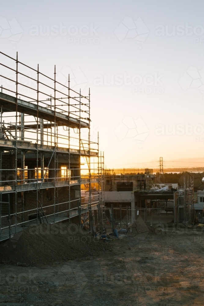 Suburban construction site with machinery and scaffolding, evening sun - Australian Stock Image