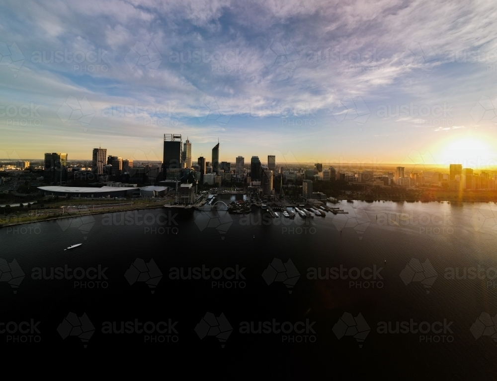 Sun almost set behind Swan River and Perth city skyline - Australian Stock Image