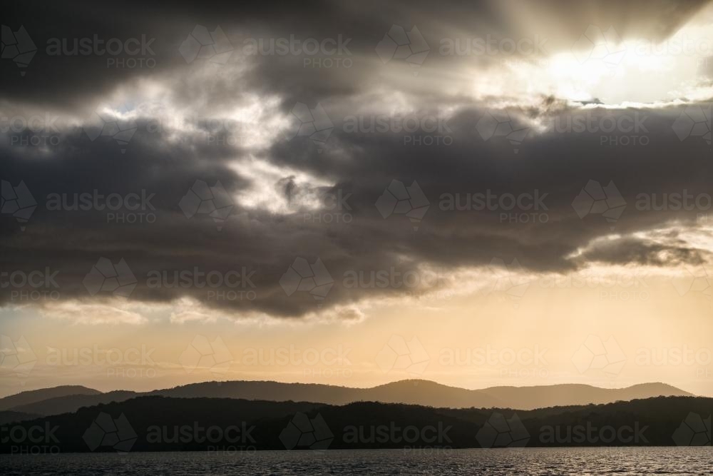 Sun breaking through above Mallacoota Inlet - Australian Stock Image
