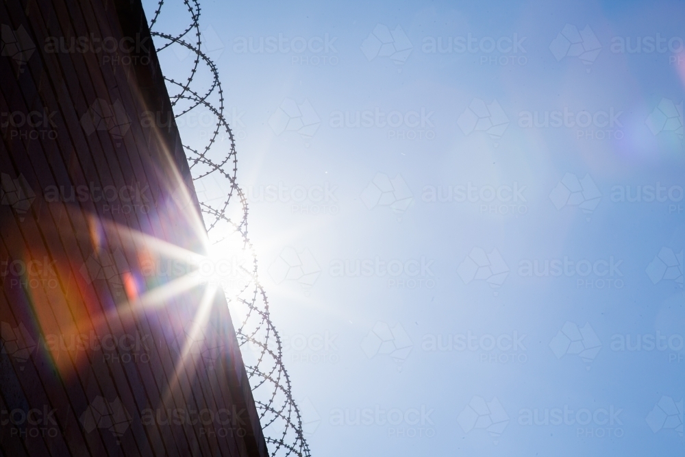 Sun flare in coiled wire on top of building - Australian Stock Image