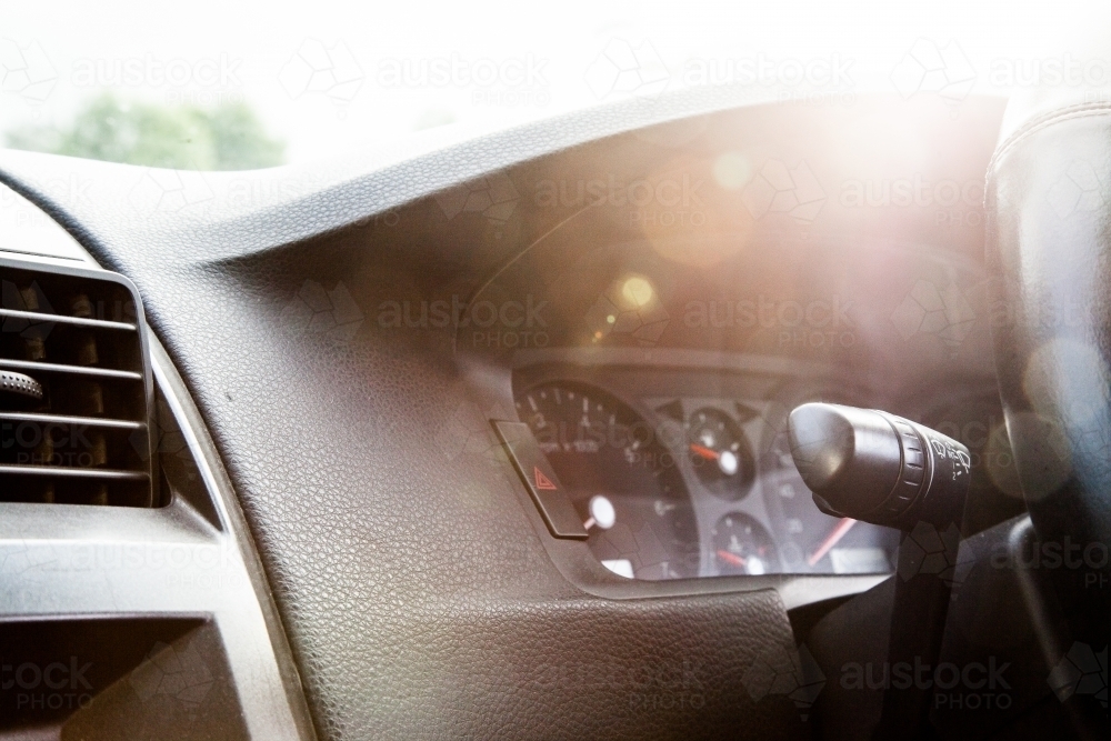 Sun flare over dashboard and speedo of car - Australian Stock Image
