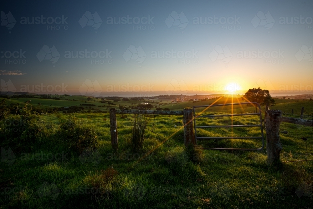 Sun setting behind a coastal farm - Australian Stock Image