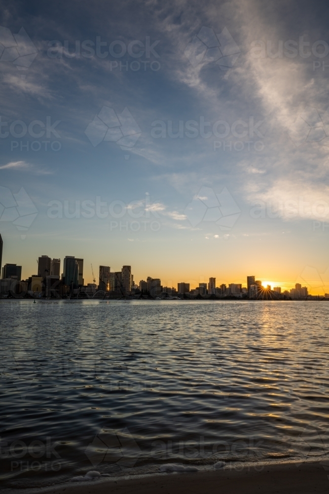 Sun setting behind Swan River and Perth city skyline - Australian Stock Image