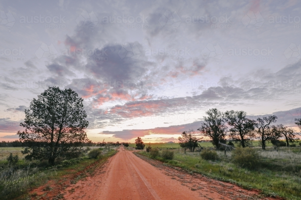 Sun setting on dirt country road in Central Victoria - Australian Stock Image
