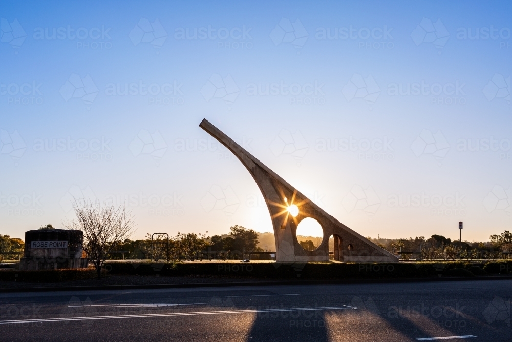 Sundial casting shadow over road at sunset in town of Singleton - Australian Stock Image