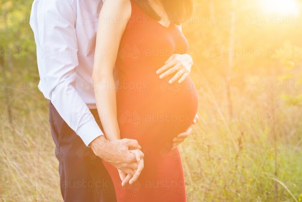 Sunflare light over pregnant woman and her husband - Australian Stock Image