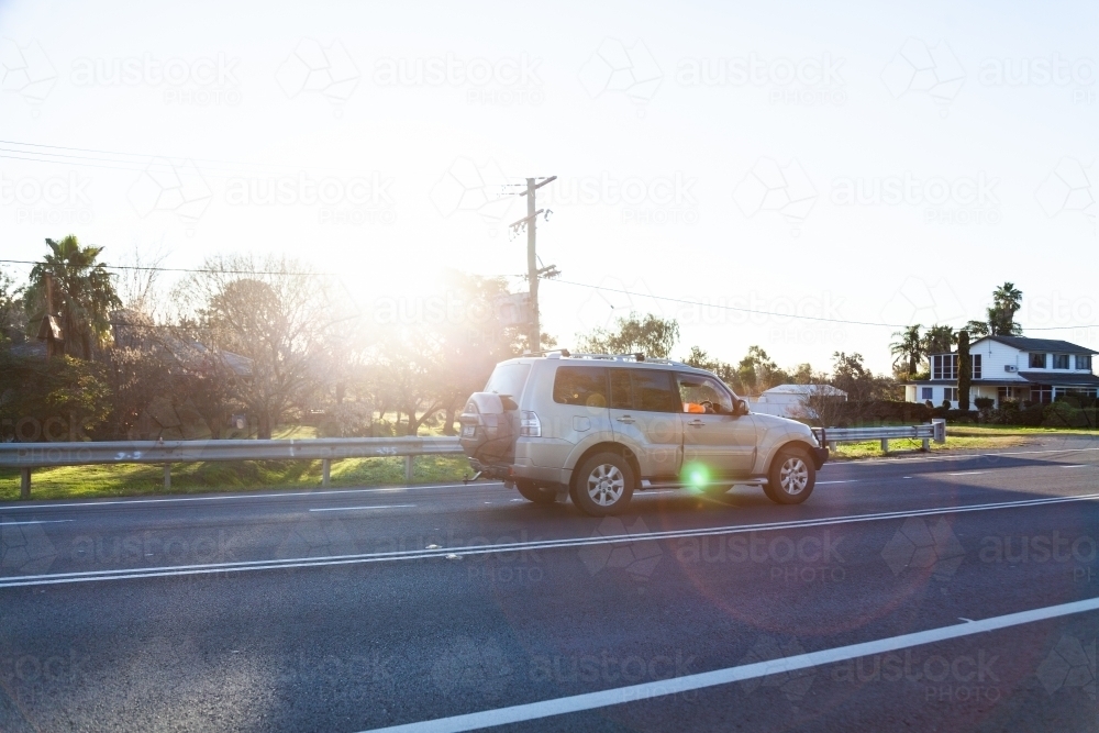 Sunlight flare over car on highway - Australian Stock Image