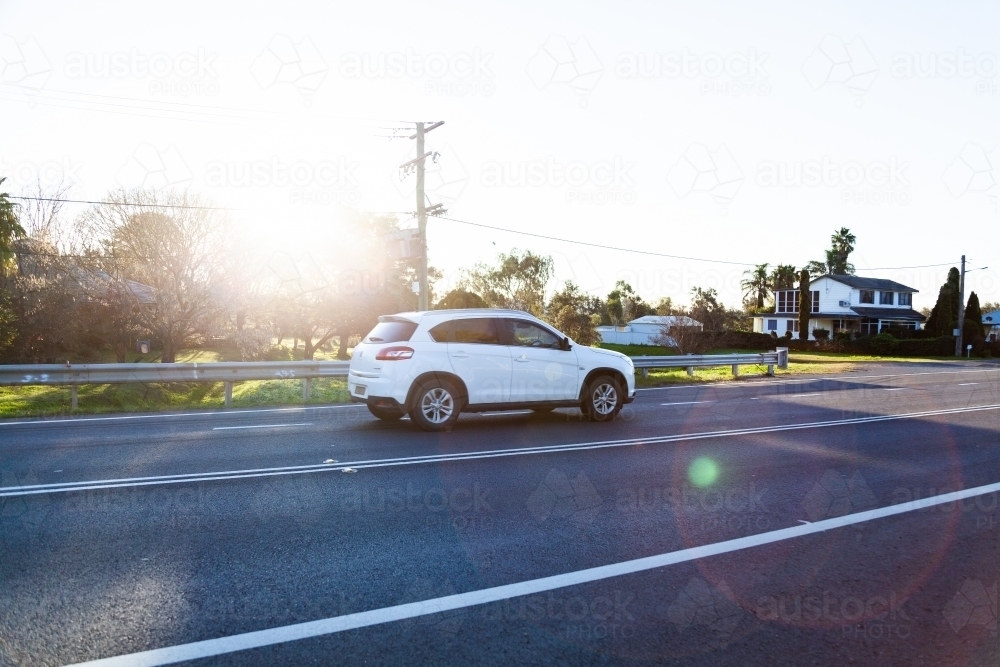 Sunlight flare over car on highway - Australian Stock Image