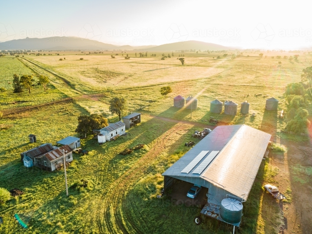 Sunlight over a farm shed with solar panels on roof - Australian Stock Image