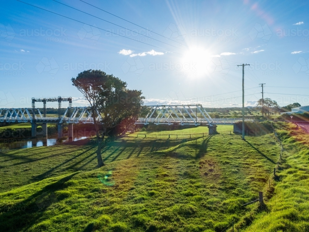 Sunlight over bridge crossing Paterson River in NSW Australia - Australian Stock Image