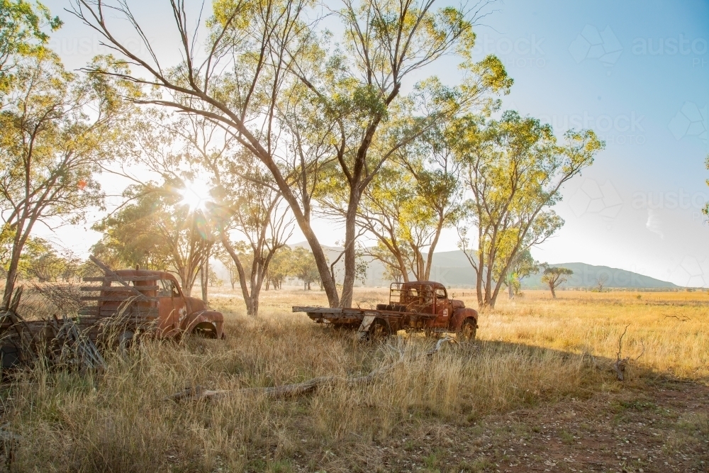Sunlight shining over farm machinery graveyard - Australian Stock Image