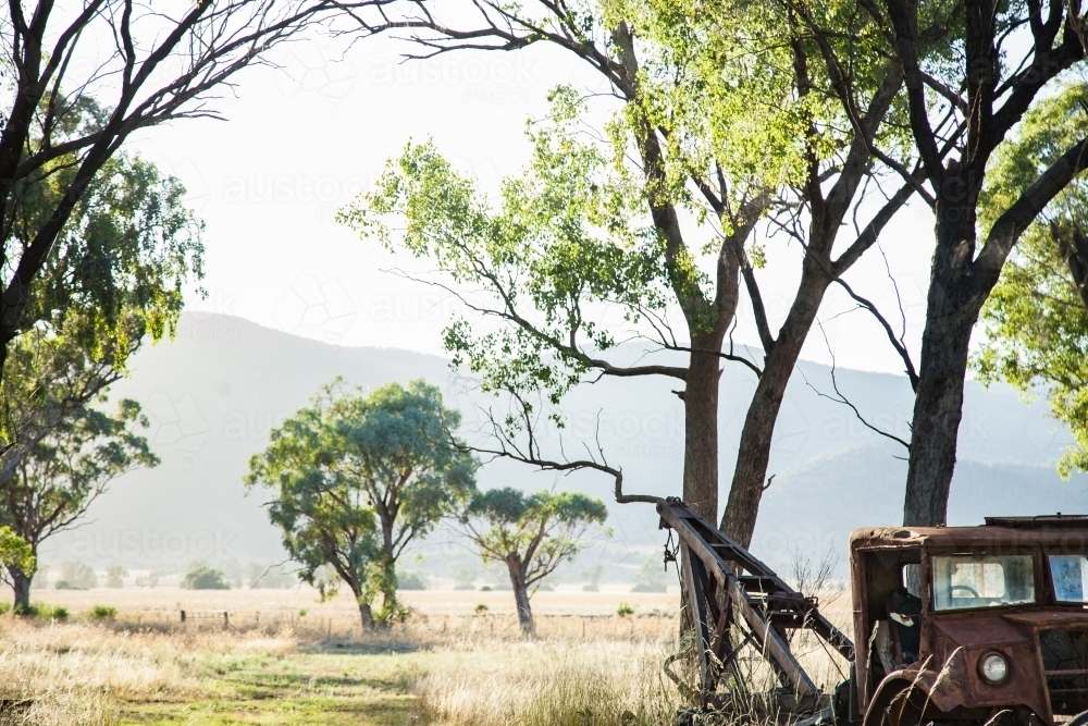 Sunlight shining over farm machinery graveyard - Australian Stock Image