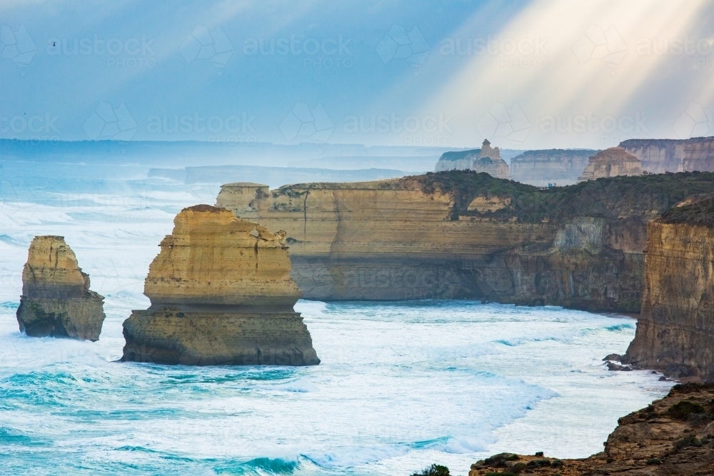 Sunlight streaming on Twelve Apostles Sea Stacks - Australian Stock Image
