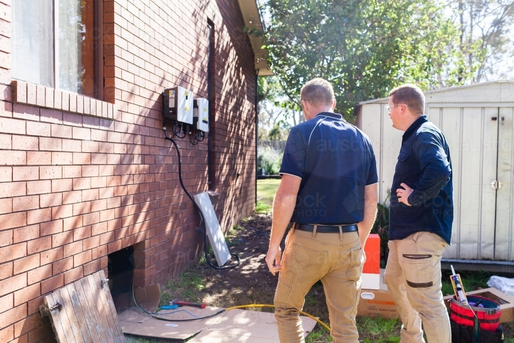sunlit electricians installing solar power to house - Australian Stock Image