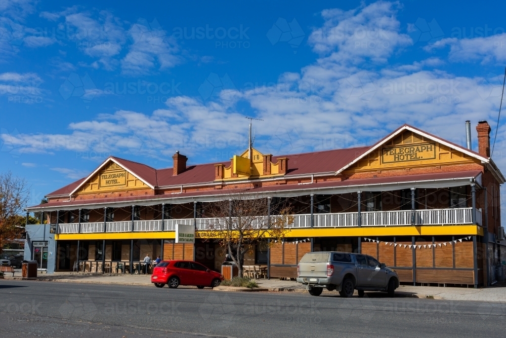 Sunlit pub hotel in country town of Gunning, New South Wales with cars parked outside - Australian Stock Image