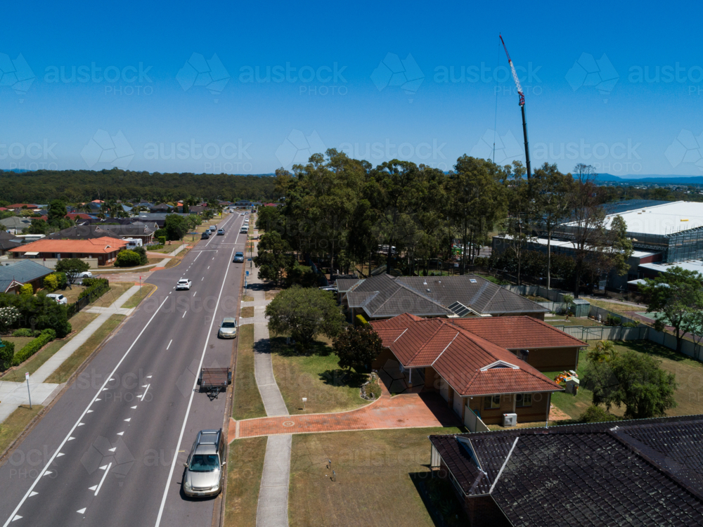 Sunlit street in suburbs with construction behind - Australian Stock Image